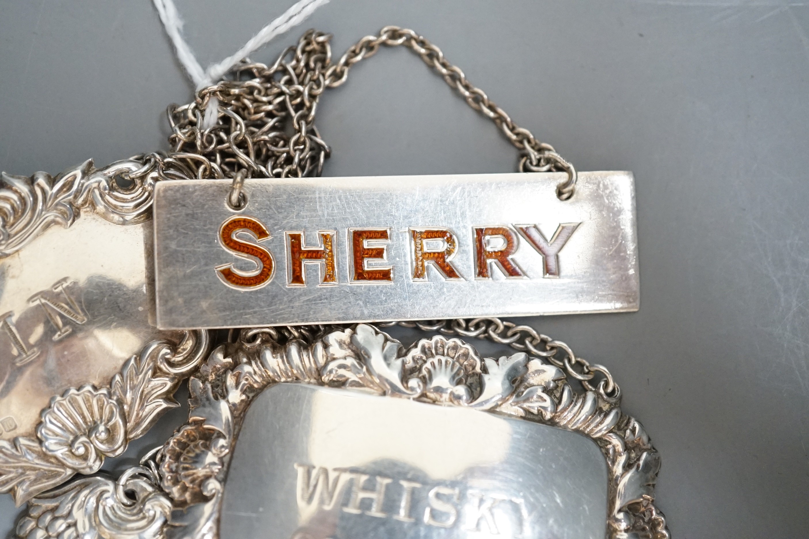 Four assorted modern silver wine labels including enamelled Sherry.